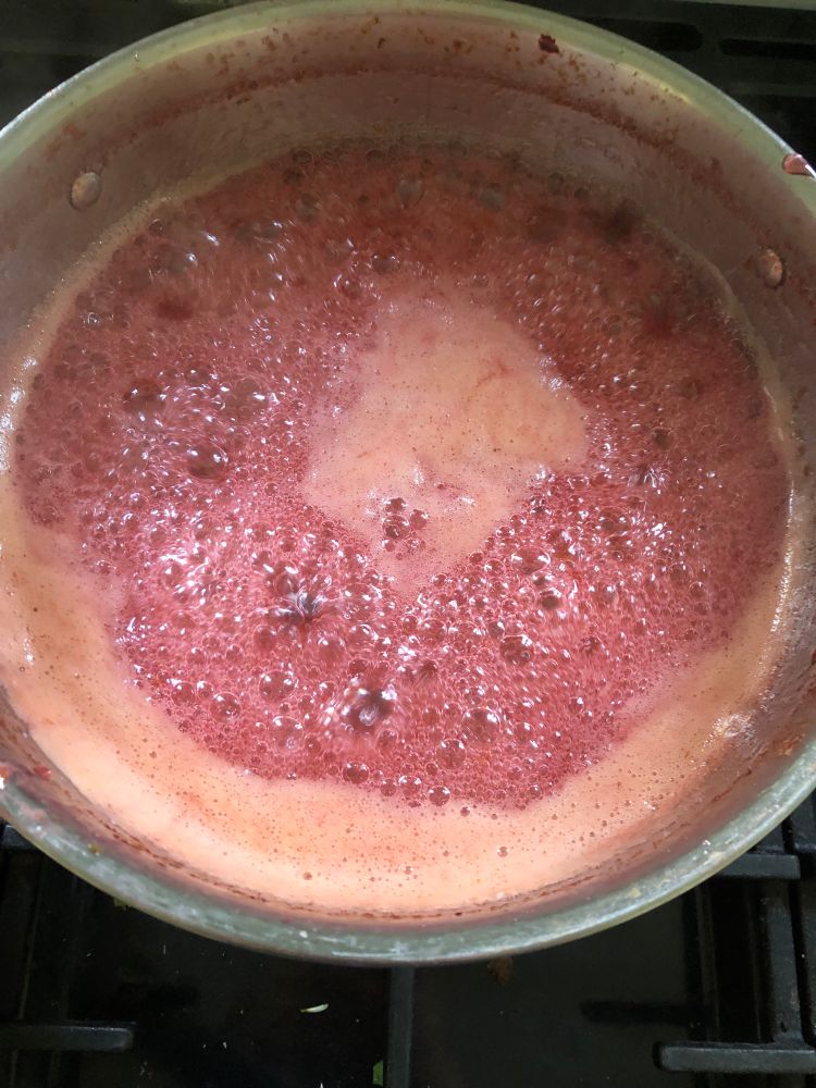 Boiling jam in a saucepan - lots of bubbles, pink froth