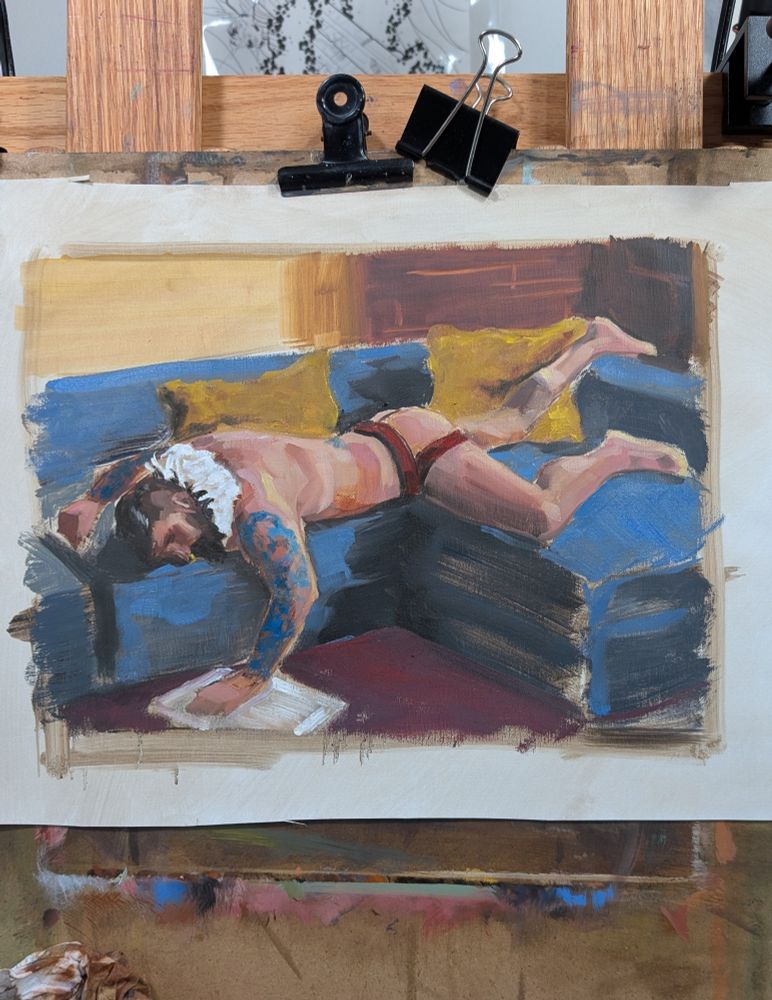 A painting of a bearded man laying on a couch, on his stomach. He wears a jockstrap and an Elizabethan collar.  He reads a book that is on the floor