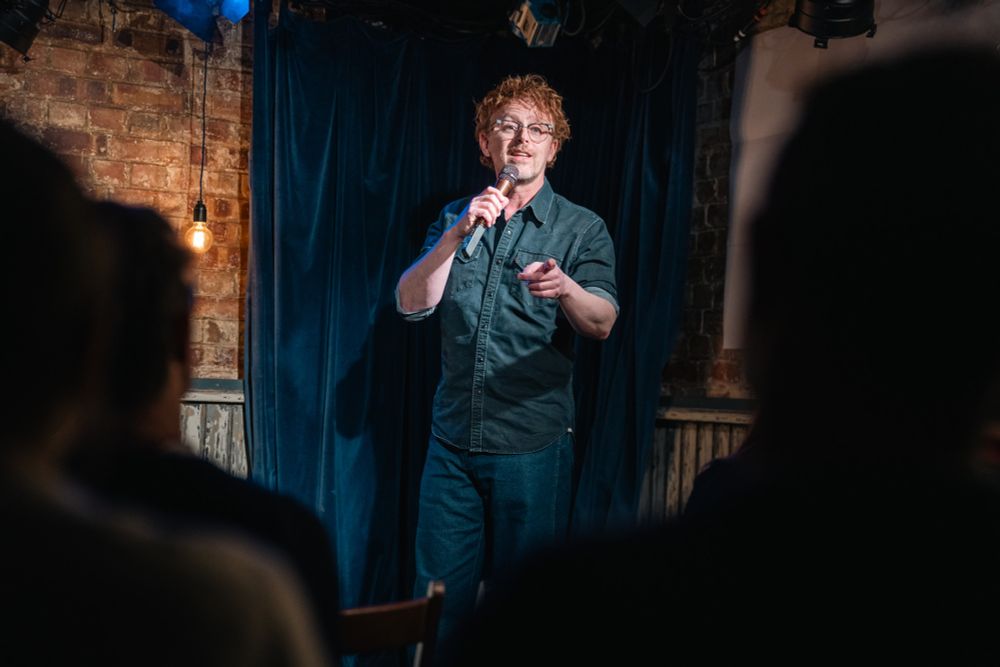 Photo of Steve Cross telling jokes. 