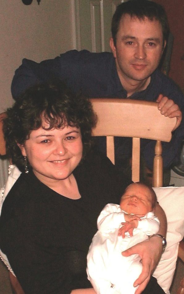 Emma holding her newborn nephew, with her brother next to her 
