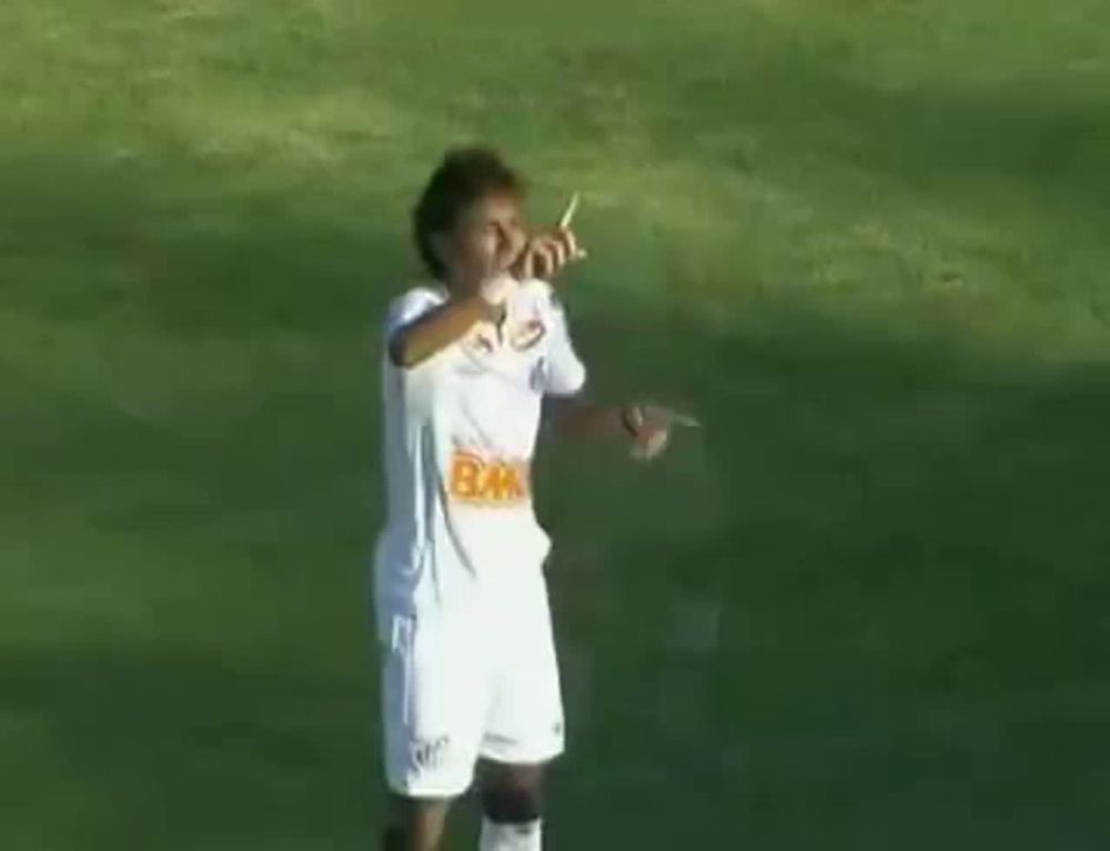 a soccer player is dancing on the field while wearing a white jersey and shorts .