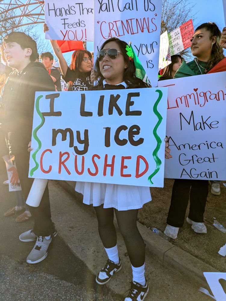A woman holds up a sign saying, "I like my ICE crushed."