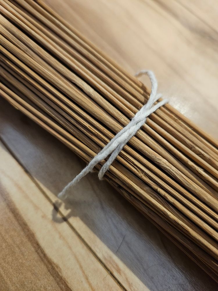 photo of a bundle of sticks tied with cotton twine in a constrictor knot