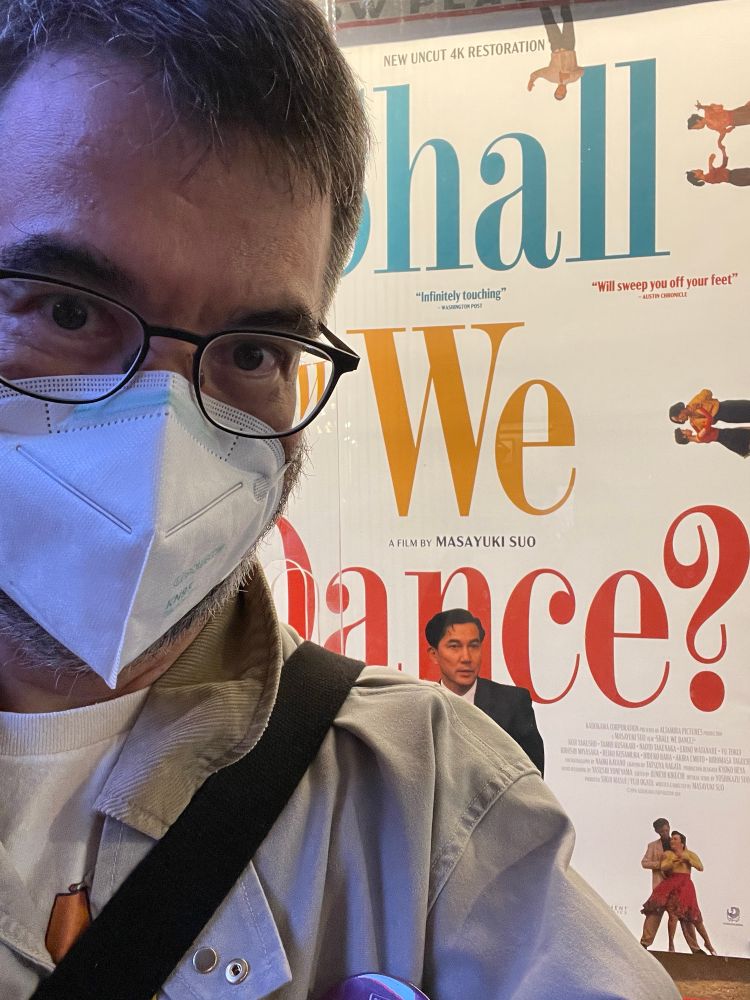 selfie of greg pak wearing a mask and standing in front of a SHALL WE DANCE poster at the film forum