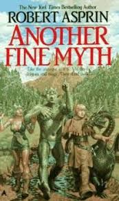 Book cover for "Another Fine Myth" by Robert Asprin.  Four characters are walking in a valley with a mountain behind them.  The woman has sturdy leather boots, a skimpy green dress and green hair. The teacher is green, scaly, and well muscled. The student is wearing brown and carrying a stick. His baby dragon is nibbling on his shirt fringe. 