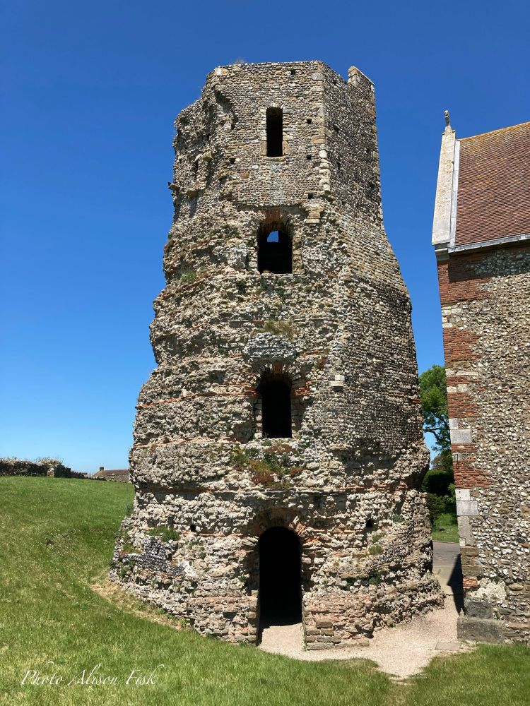 My photo shows the ruins of an eight-sided Roman brick lighthouse with four stepped levels. There is a doorway at ground level and narrow rectangular window openings above on the upper three levels. It stands 15.8 m high and is 12.2 metres wide at the base. Roman fabric survives to a height of 12.5 m. The brickwork of the uppermost level was reconstructed for use as a church bell tower, for the adjacent Anglo-Saxon church of St Mary in Castro of which a small portion can be seen in my photo. The Pharos is dated 1st century - early 2nd century AD and is one of a pair originally built on the headland flanking each side of the Roman port of Dubris (Dover). It now stands within the grounds of Dover Castle.