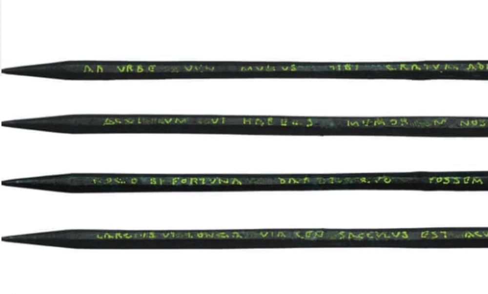 The photo shows a Roman iron stylus pen used to write on wax-filled wooden writing tablets. It has an inscription which runs along its length on four sides. The image shows the four lines of inscribed text which read:

‘ab urbe v[e]n[i] munus tibi 
gratum adf(e)ro acul[eat]um ut habe[a]s memor[ia]m nostra(m) rogo si fortuna dar[e]t quo possem largius ut longa via ceu sacculus est (v)acuus’

‘I have come from the City. I bring you a welcome gift
with a sharp point that you may remember me. I ask, if fortune allowed, that I might be able (to give)
as generously as the way is long (and) as my purse is empty.’

Excavated in London by MOLA. Photo by Juan Jose Fuldain/MOLA