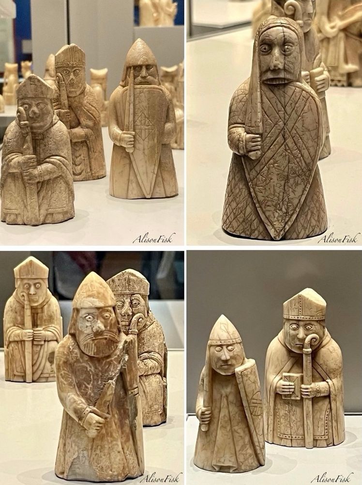 My photo collage shows a selection of bishop and warder (rook) Lewis chess pieces carved from walrus ivory c. 1150-1200 AD.

Photo top left: Two bishops and a warder. All standing. The bishops wear long garments and mitre (headgear) and hold a crozier with both hands. The bearded warder wears a long pleated garment and conical helmet with neck and ear-pieces. He is armed with a sword and kite-shaped shield inscribed with a lozenge shaped cross.

Photo top right: A so-called ‘berserker’ (warder) chess piece. Standing, wearing a long garment and hood, armed with a sword and shield decorated with an interlaced saltire. The warder has large, wide- open eyes, and large upper teeth which bite the top of the shield. Height 8.2 cm.

Photo bottom left: A standing warder and two seated bishops, one of which is partly obscured by the warder. The bearded warder wears a long pleated garment and conical helmet with neck and ear-pieces, and is armed with sword and shield. The seated bishops wear long garments, mitres, and each holds a crozier and a book.

Photo bottom right:  A warder and a bishop, both standing. The bearded warder wears a long pleated garment, and conical helmet with neck, ear-pieces and ornamented head-band. He is armed with a sword in right hand and kite-shaped shield in left hand. His eyes look to the left. The bishop wears a long garment with cloak, and mitre, and holds a crozier in his left hand and a book in his right hand.