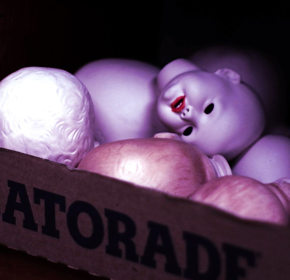 Cardboard Gatorade box of baby doll heads