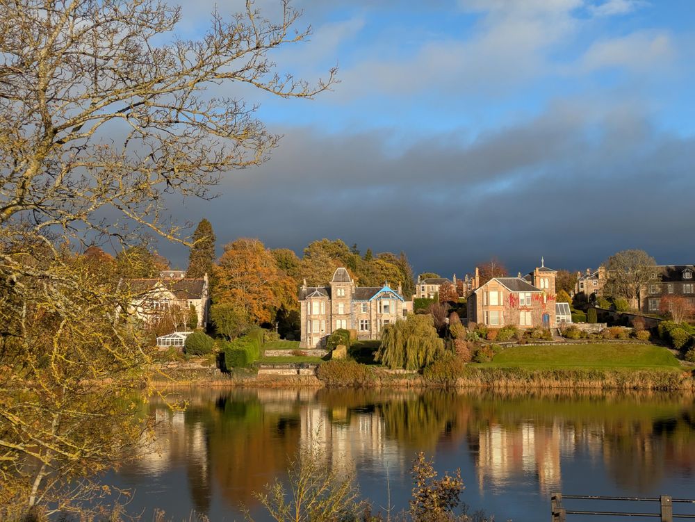 Large riverside houses reflected in the water