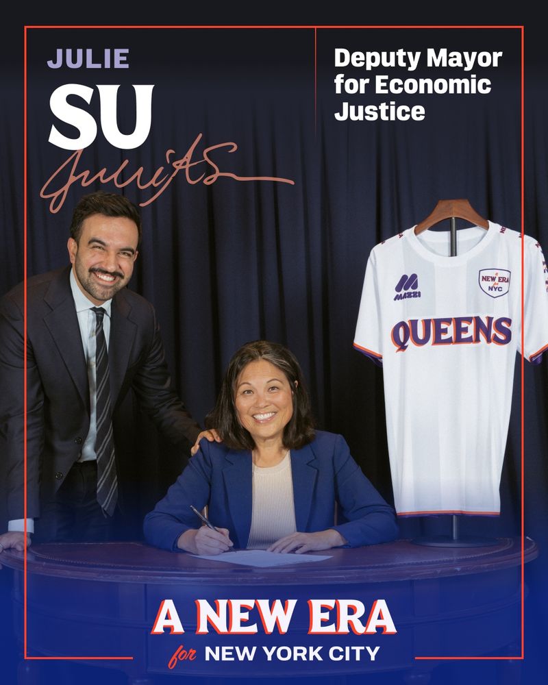 Julie Su sat at a table signing a paper, with Mayor-elect Zohran Mamdani on the left and a white soccer jersey with Queens written on it hanging on the right. Mimicking a sports team signing a major player graphic.

“Julie Su” written and signed in the top left and “Deputy Mayor for Economic Justice” written on the top right.