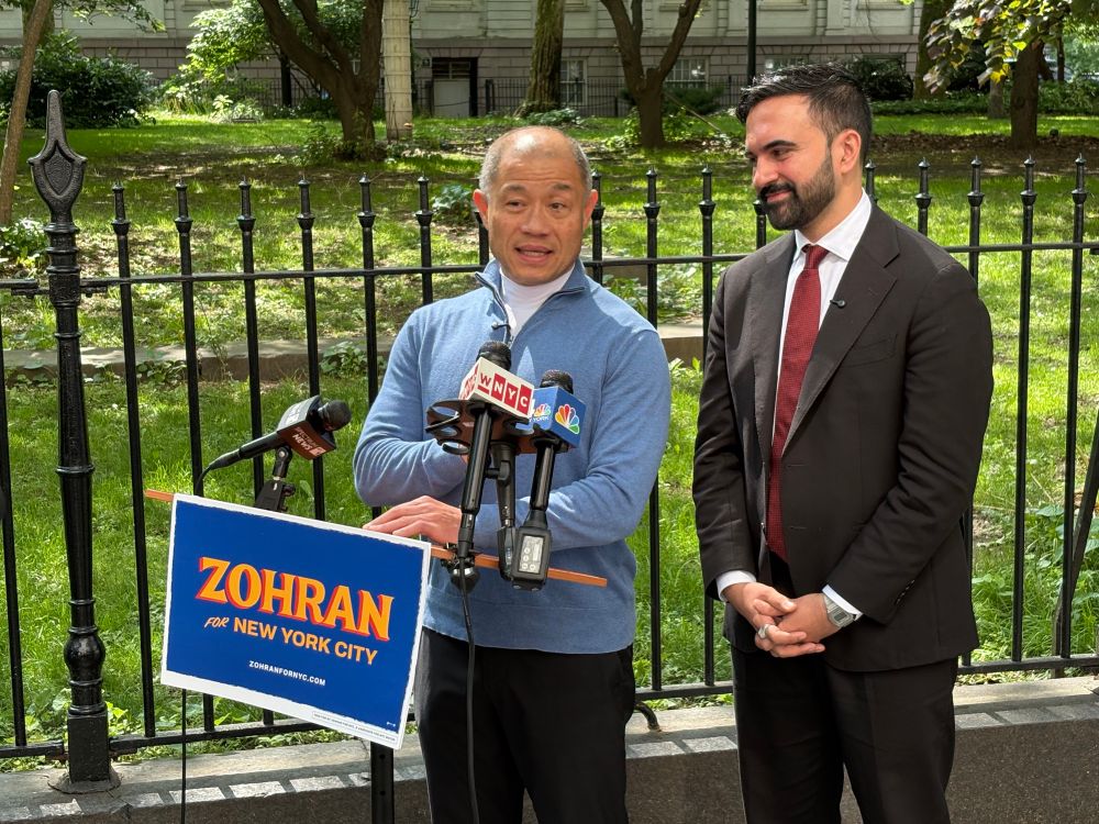 Senator John Liu and Zohran standing at a podium in front of City Hall. 