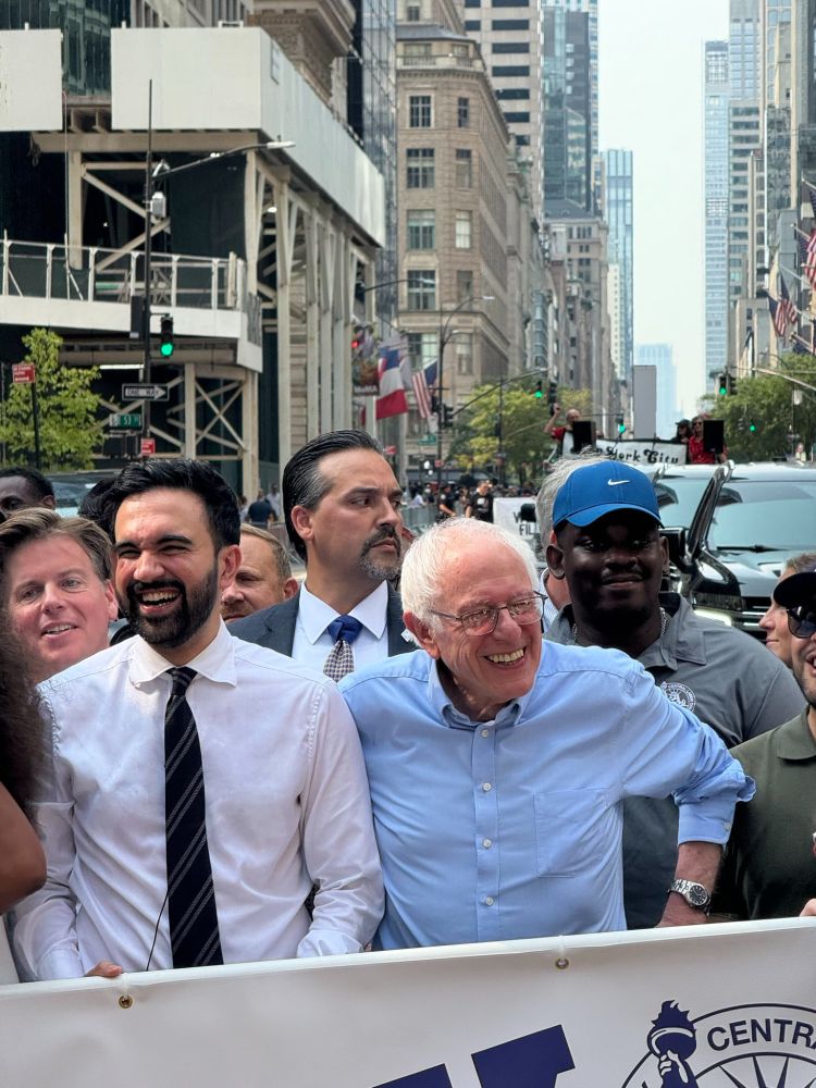 Zohran and Bernie smiling at the front of the parade.