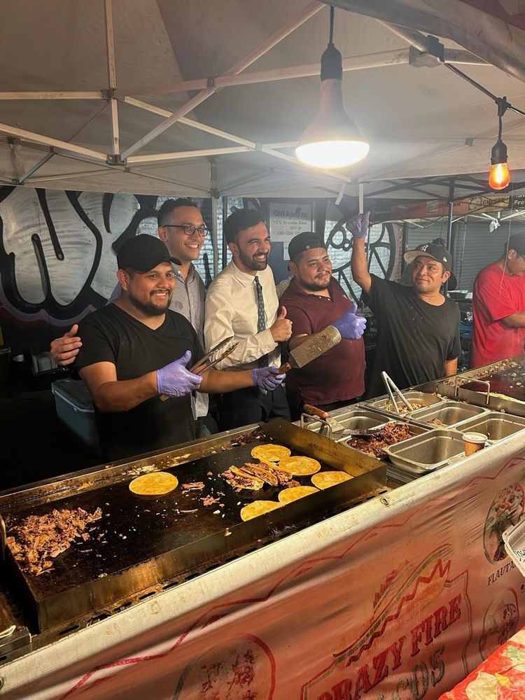 Zohran behind the counter with food vendors 