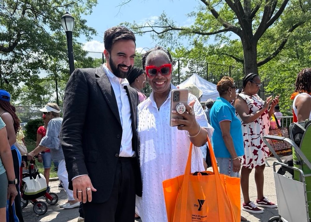 Zohran posing with a woman taking a selfie.