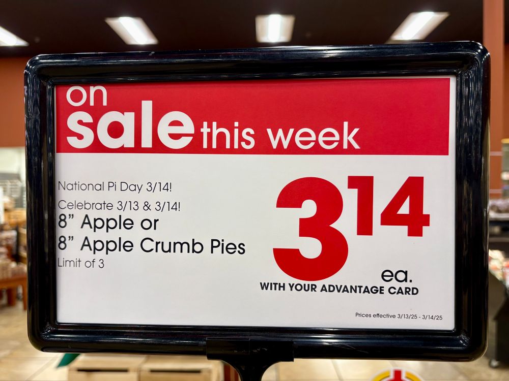 a red and white sign at Giant Eagle advertising apple pies for $3.14 on Pi Day 