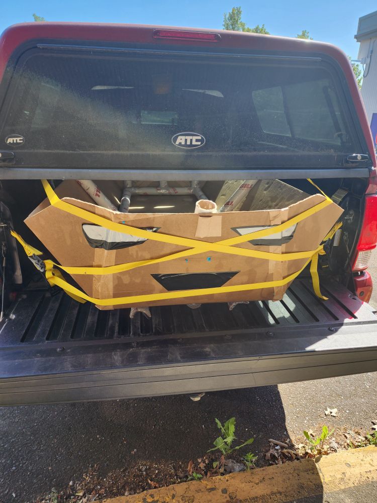 Cardboard boat with face in the back of a truck