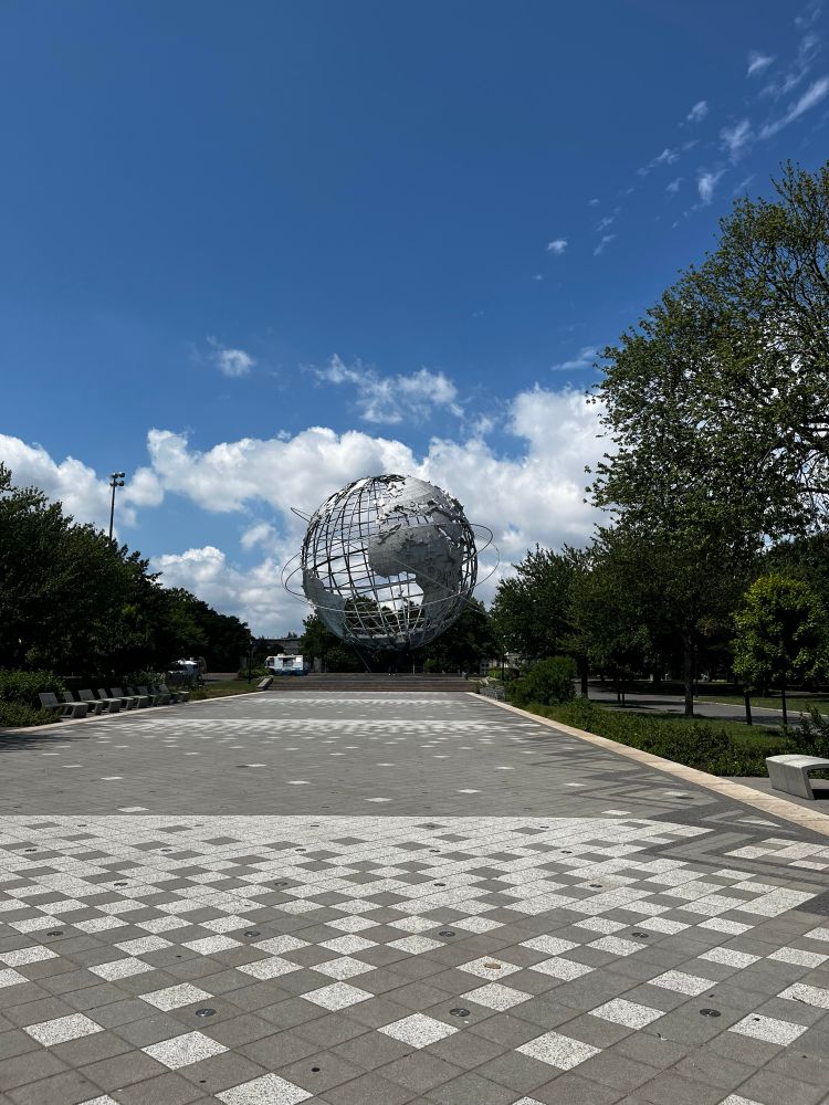The metal globe sculpture from the center of Flushing Meadows Corona Park in Queens, New York on a sunny July day seen from a distance