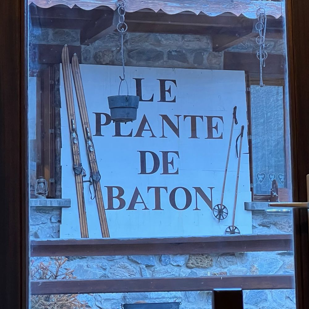 A sign for “Le Plante De Baton” in the French town of Val d’Isere. Several of the seriffed all-caps letters are upside down or back to front.
