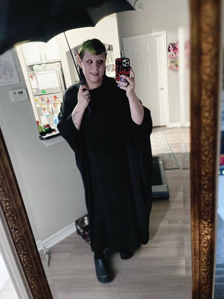 Selfie of a vampire costume from the nightmare before Christmas. They are holding a gothic umbrella. 