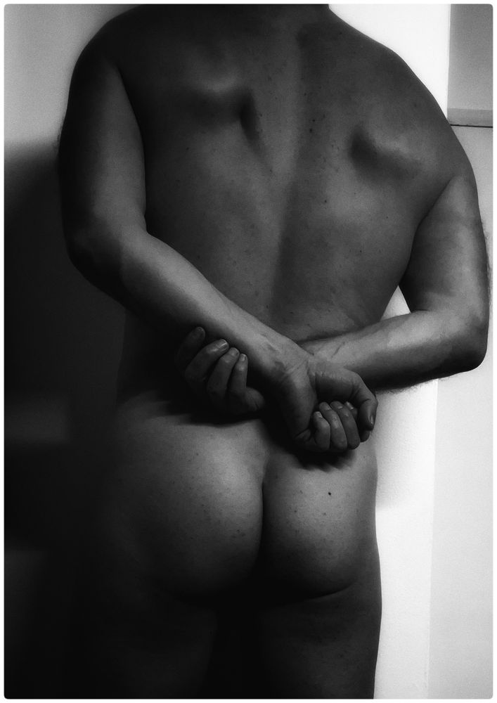 Moi de dos nu contre un mur et les mains dans le dos.