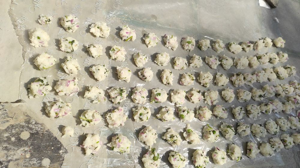 Poha, onions, green chili, kothmeer vadams being sun dried on a plastic sheet. 