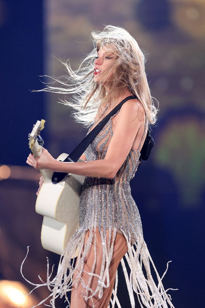 Taylor swift with silver strappy fearless dress during the eras tour