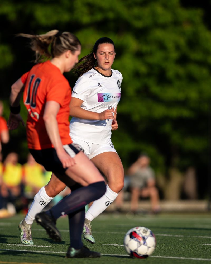 McKenna Lehman attacking an opponent with the soccer ball.
