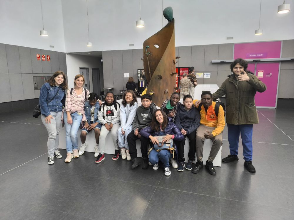 La imagen muestra a los alumnos y alumnas del CEIP Julián Sanz Ibáñez junto a una auxiliar de Educación Especial posando en el hall del Edificio Josemi Monserrate