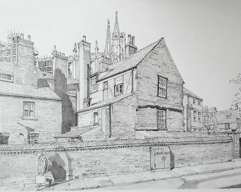 Pencil drawing of a person walking past a high brick wall in front of houses. One of the houses has some timber framing visible with York Minster visible through a collection of tall chimneys. 