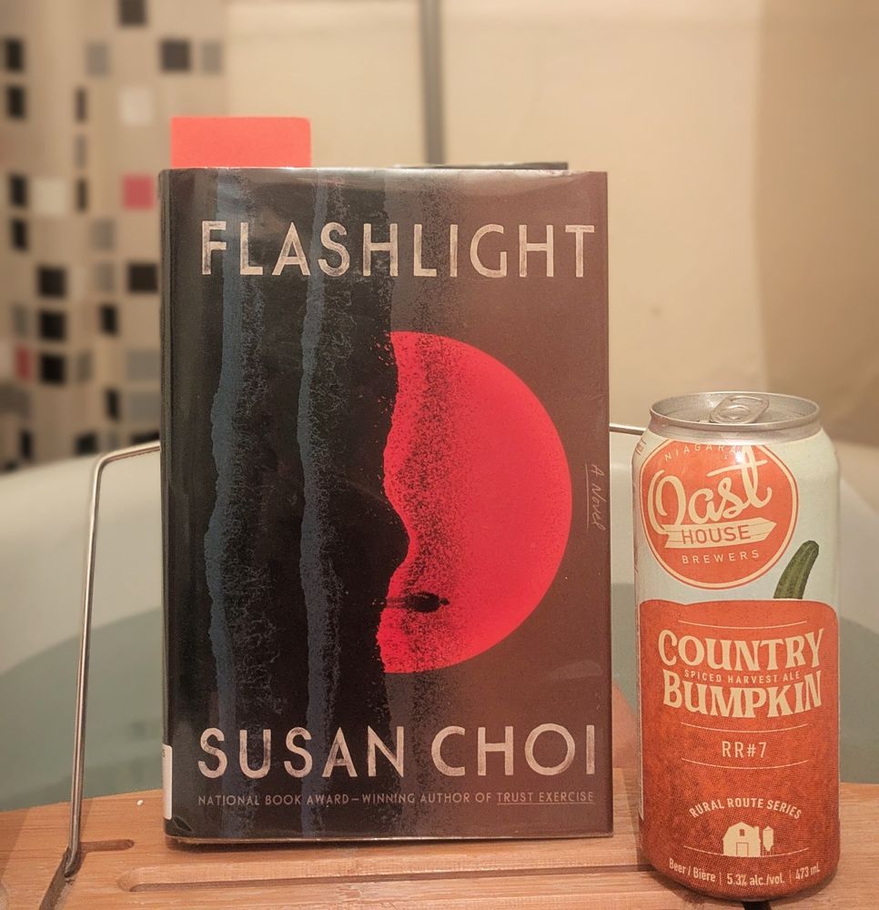 Flashlight by Susan Choi sits on a bath tray with a can of Oast House Country Bumpkin beer. 