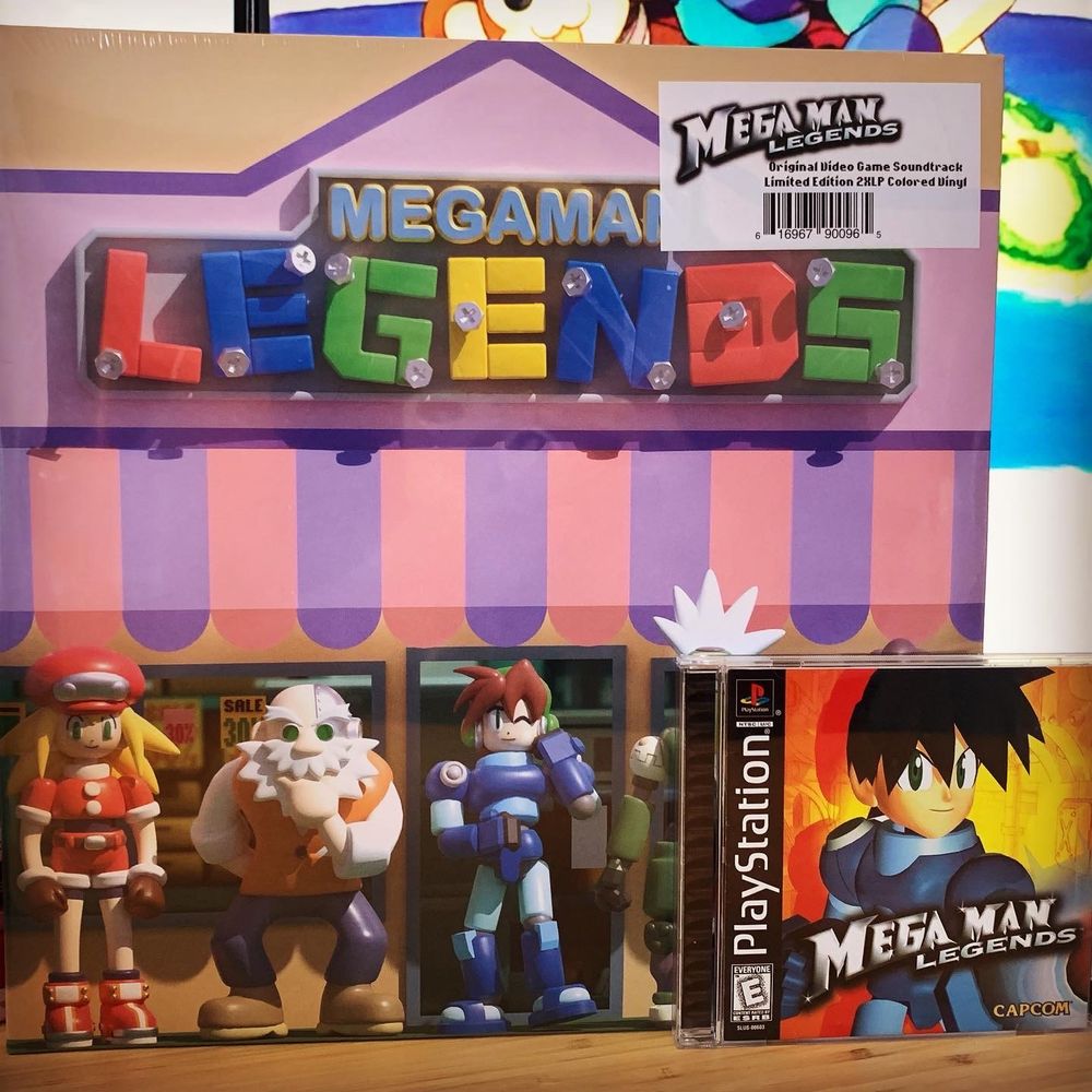 The video game Mega Man Legends on PS1 sits in front of the vinyl for the Mega Man Legends soundtrack.