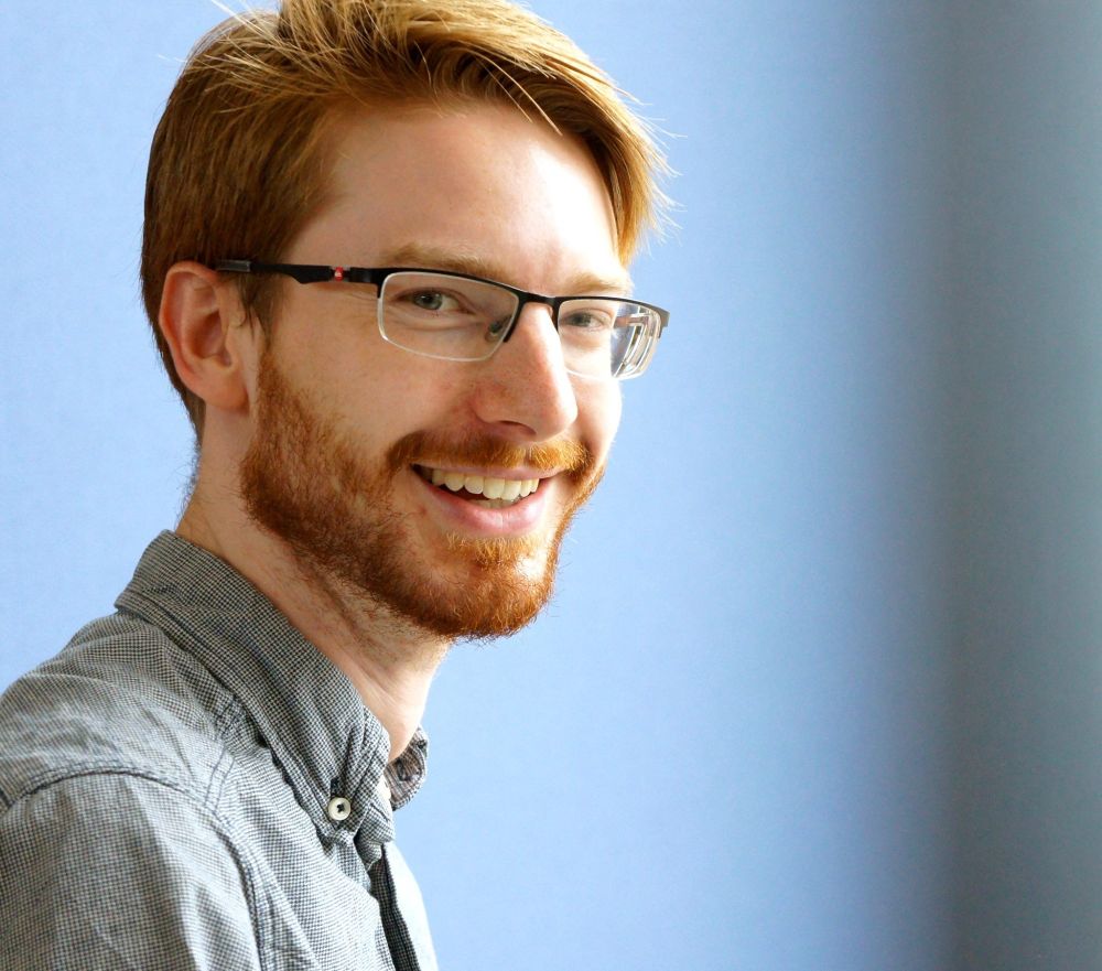 portrait picture of neil tomas smith with blue background
