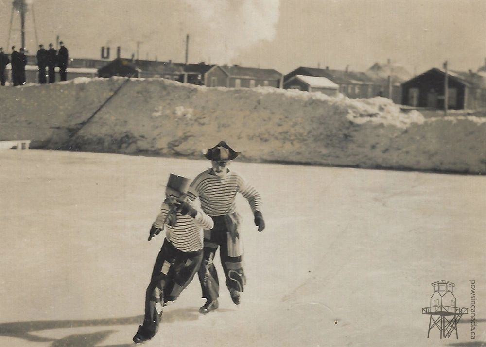 Black and white photo of two men performing a ice-skating routine dressed as clowns at Prisoner of War Camp 23 (Monteith).