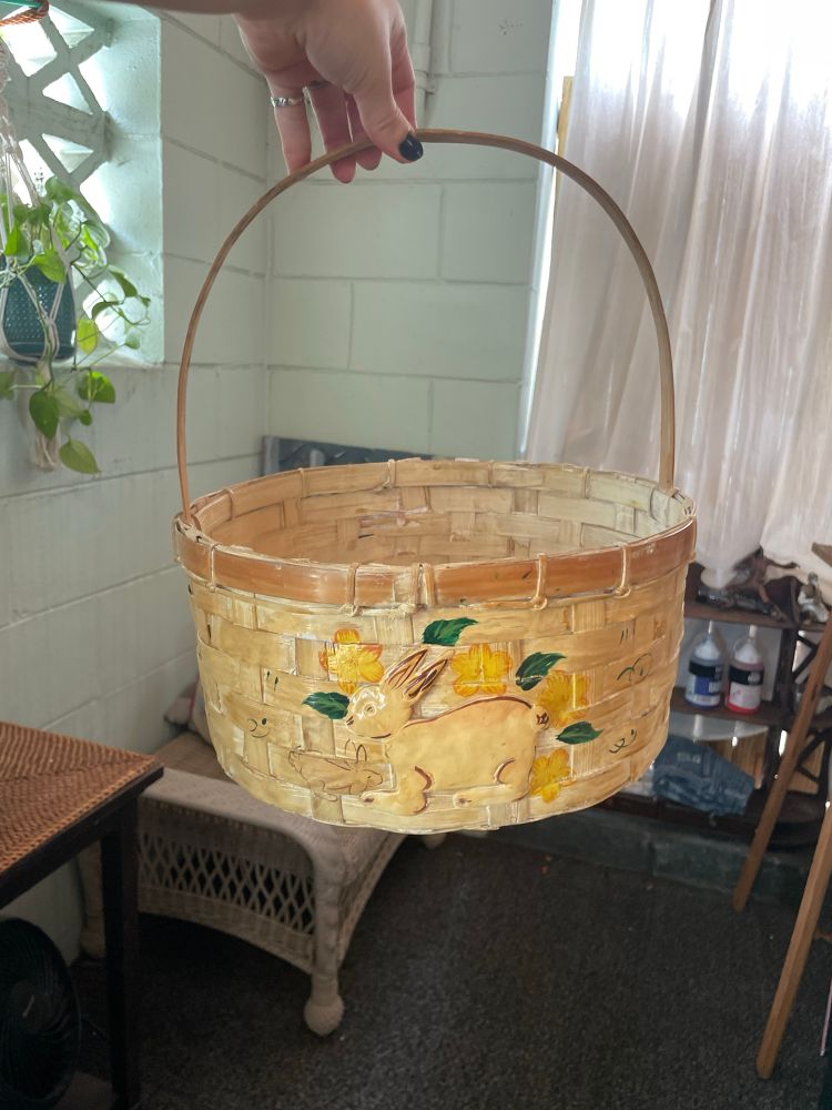 a whicker basket with a rabbit and painted flowers