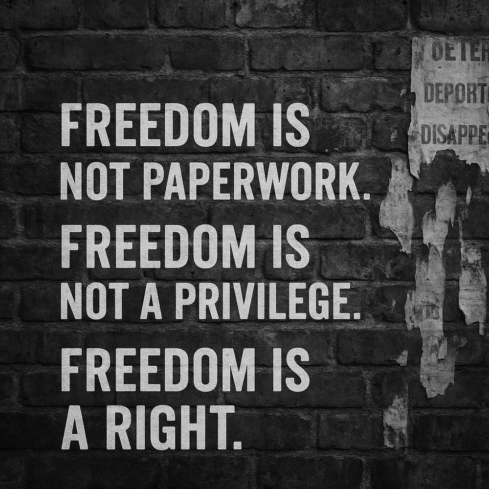 A rugged red brick wall marked by white spray-painted text: “FREEDOM IS NOT PAPERWORK. FREEDOM IS NOT A PRIVILEGE. FREEDOM IS A RIGHT.” The paint is chipped, uneven, and stark against the bricks, giving the image the energy of urgent protest, raw voice, and unapologetic public resistance.
