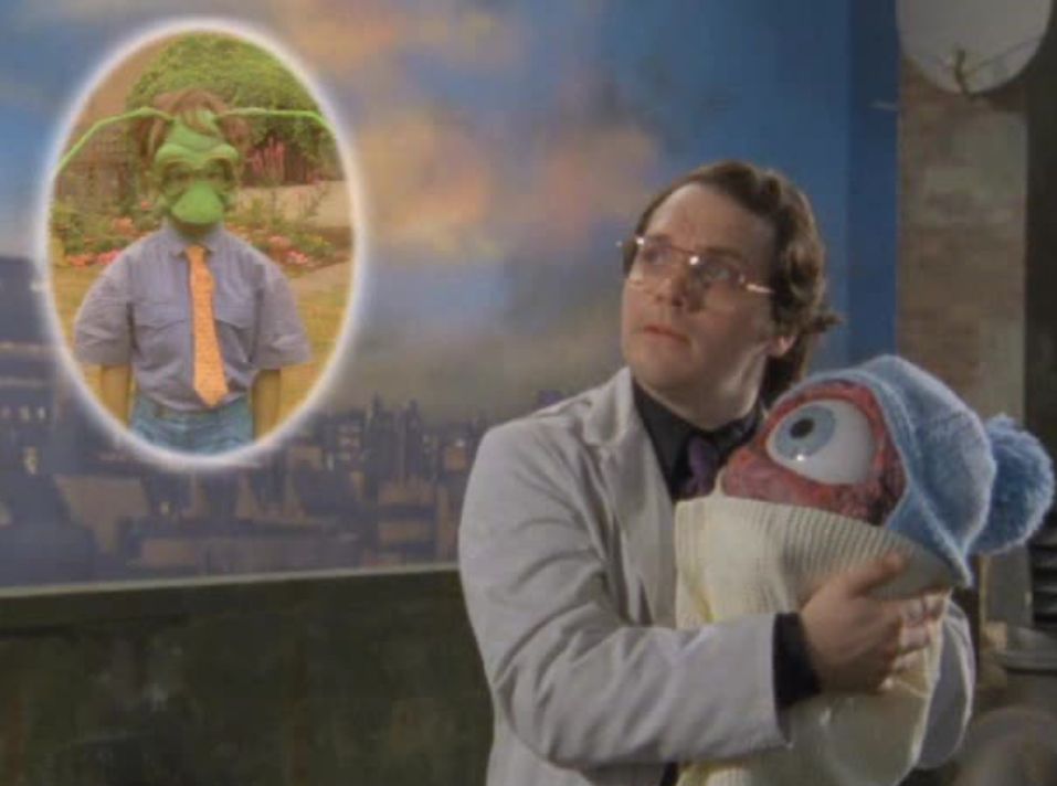 Garth Marenghi holding the eye baby while thinking about his dead son Skipper