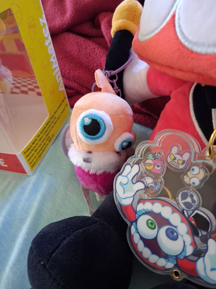 A zoomed up photo focusing on Kinger Plush Keychain and a bit on the Caine Shaker Keychain.