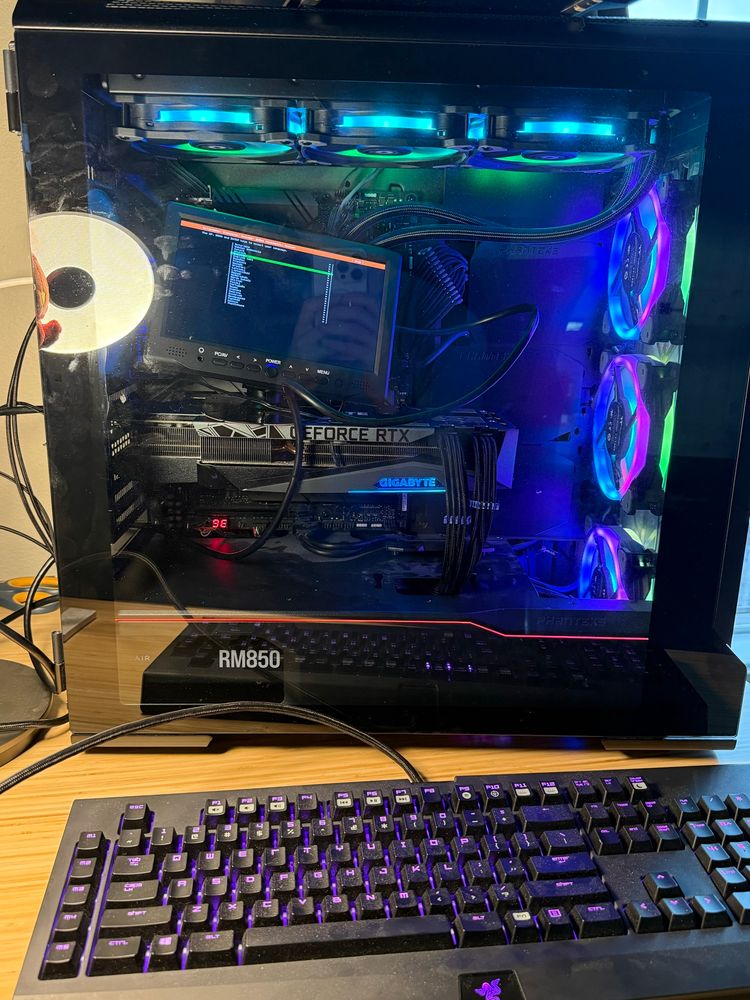 A desktop computer with a tiny monitor inside on top of the graphics card.