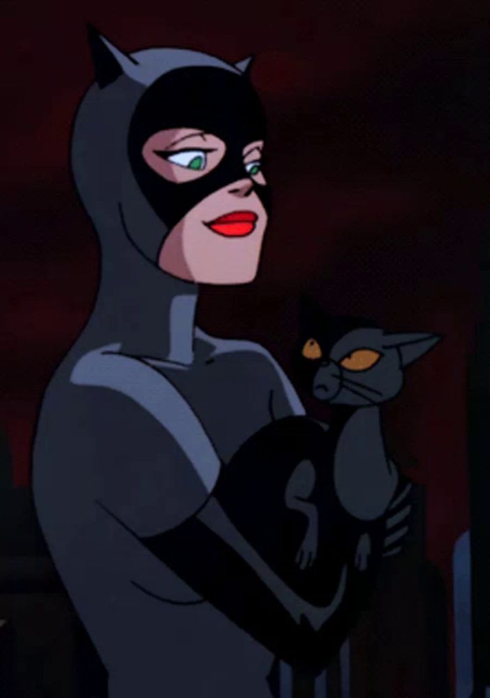 a woman in a catwoman costume is holding a cat in her arms