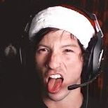 Josh Dun during the Christmas livestream giving stinkface with his tongue out, but he’s wearing a Santa hat and a headset
