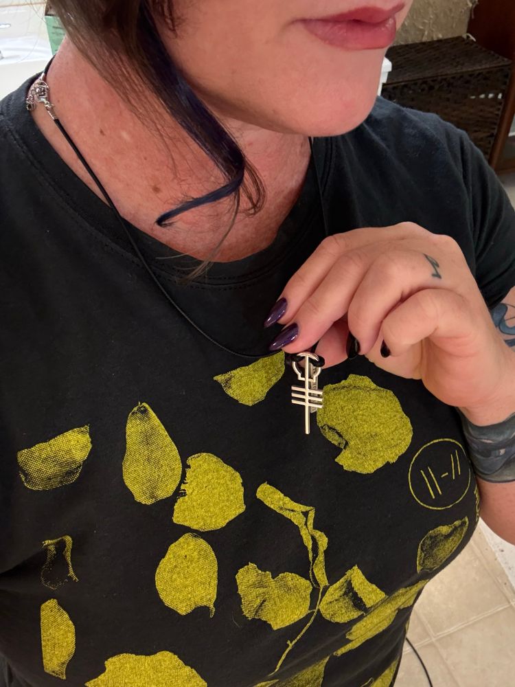 Me, holding up the skeleton key necklace that I am wearing. I’m also wearing a charcoal gray top shirt with yellow flower petals, which was a gift from Barb.