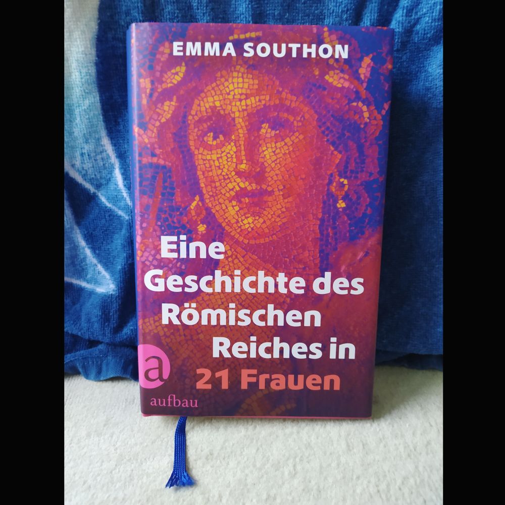 Cover eines Buches von Emma Southon mit dem Titel: Eine Geschichte des Römischen Reiches in 21 Frauen. Mosaik eines Frauenkopfes in Routinen, dahinter ein blaugemustertes Handtuch.