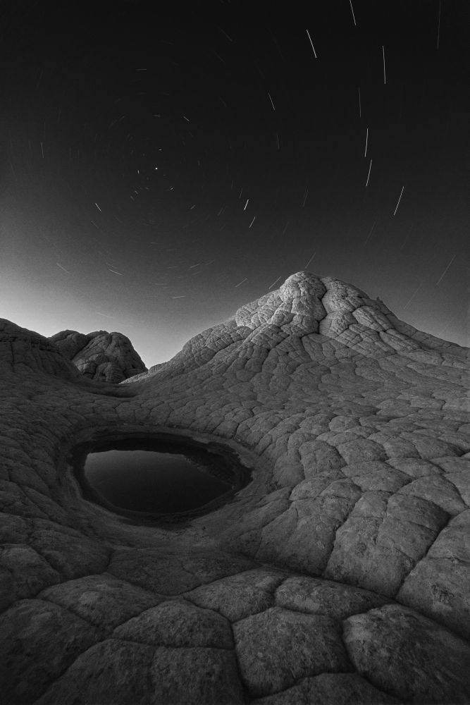 Long exposure photograph of stars over brain rock formations 