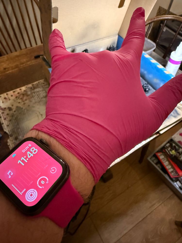 A very pink Apple Watch, a very pink nitrile glove, and the most ad-hoc airbrushing station of all time
