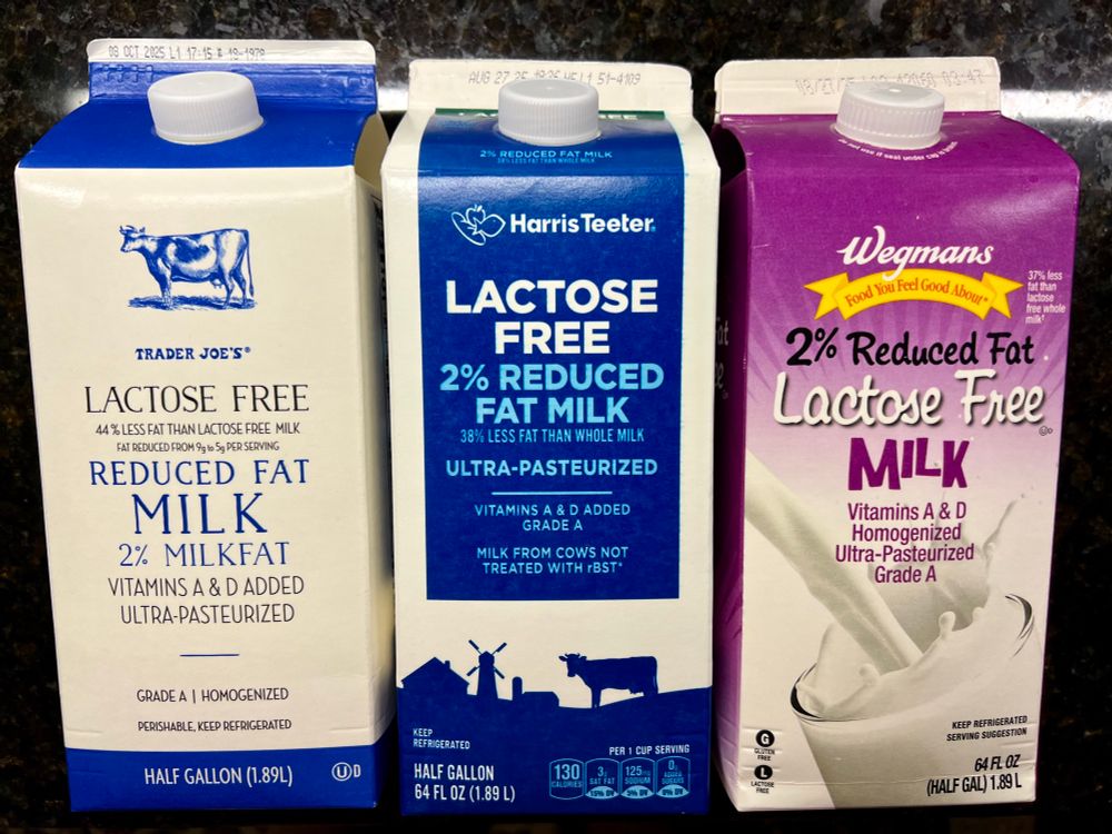 The front of Lactose-free 2% reduced fat half gallon milk cartons from Trader Joe’s, Harris Teeter, and Wegmans.
