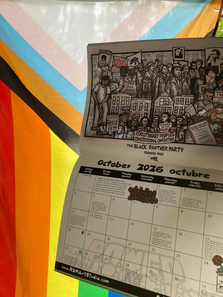 Brightly colored, rainbow flag background. To the right of the image, a calendar with its pages open to the month of October. 