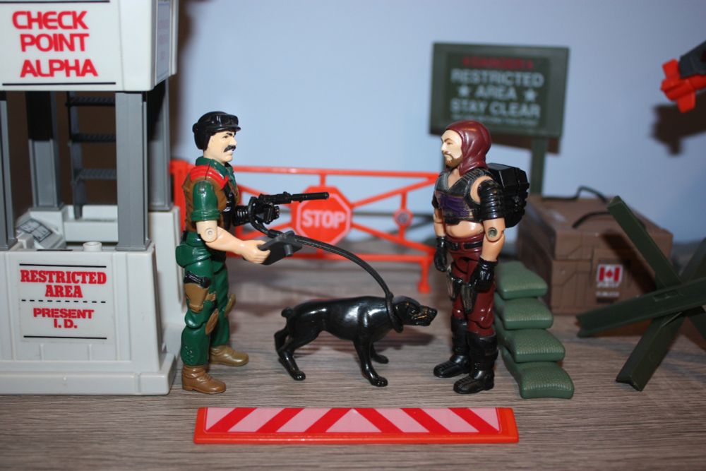 Mutt and Junkyard question Zartan (wearing a mask) in front of Check Point Alpha.