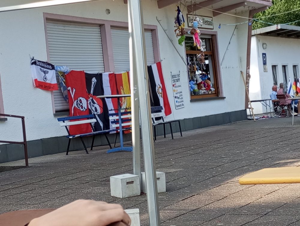 Auf dem Bild ist zu ein Stand mit Flaggen zb Piratenflagge oder Reichsflagge
