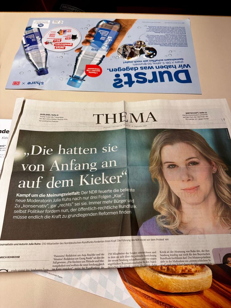 Fotos eines aus der ZEIT rausgerissenen Artikels, der auf einem Tisch im Bordbistro der Bahn liegt.
Porträt von Ruhs:
»Die hatten sie von Anfang an auf dem Kieker®
Kampf um die Meinungsvielfalt: Der NDR feuerte die beliebte neue Moderatorin Julia Ruhs nach nur drei Folgen „Klar".
Zu „konservativ", gar „rechts" sei sie. Immer mehr Bürger und selbst Politiker fordern nun, der öffentlich-rechtliche Rundfunk